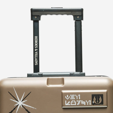 Beige suitcase with 'Heroes & Villains' branding on a white background