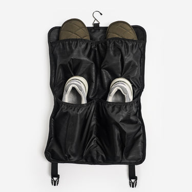 Black hanging shoe organizer with shoes inside on a white background