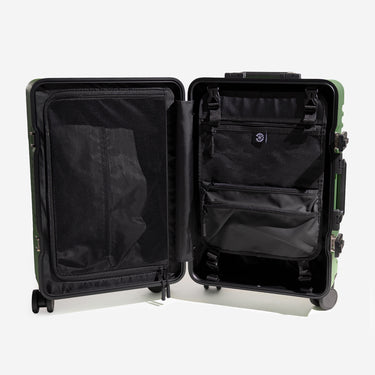 Open suitcase with black interior showing zippered compartment and removable toiletry hanger on a white background