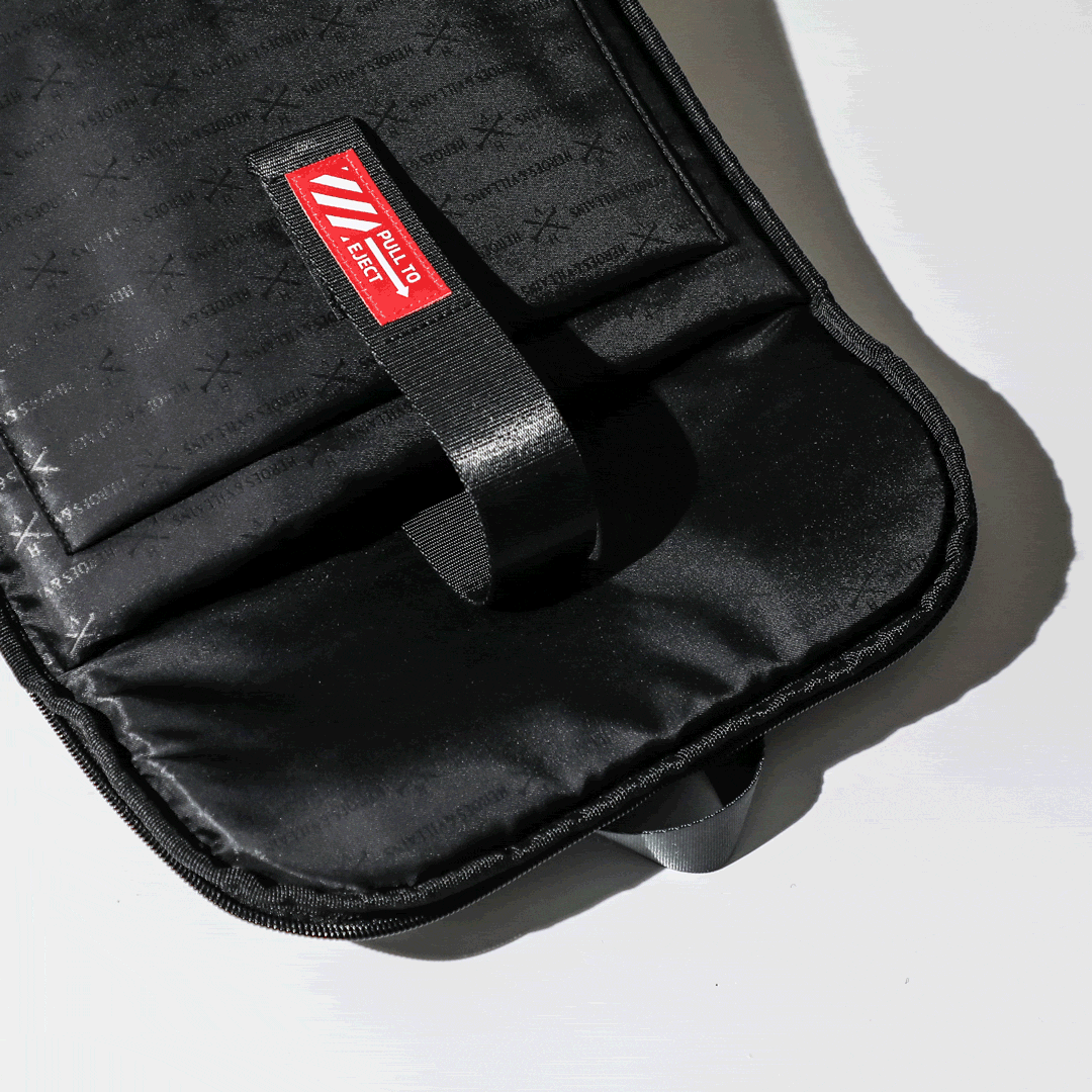 Gif showing laptop being pulled out of a backpack using a strap that says "eject"