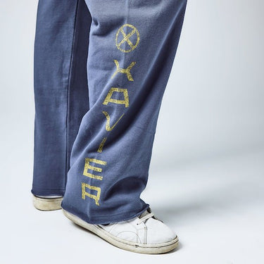Close up detail of sweatpants. The leg has "Xavier" in yellow text down the leg