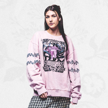 Female model wearing Breathe In Breathe Out Blush Crew Sweatshirt in front of a floral background
