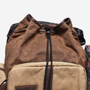 Brown and beige backpack with cinch closure  on a white background