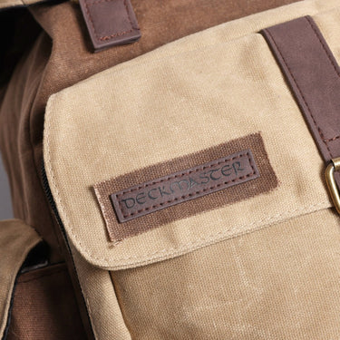 Close-up of a beige bag with a brown leather patch featuring 'DeckerMaster' patch