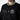 The photo shows a man in a black jacket. The jacket features a green & beige striped cuff on the neckline. The Jacket is a snap button closure. There is embroidered text on the left chest and a patch on the right patch. 