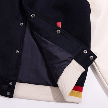 Navy blue Superman Themed Varsity jacket with white and red accents on a light gray background