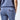 Close up of a person wearing blue sweatpants with a back pocket