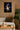 Canvas print of a movie poster on a wall above a sofa with a plant and wooden table.
