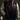 Person wearing a Superman-themed letterman jacket with a logo on a dark background