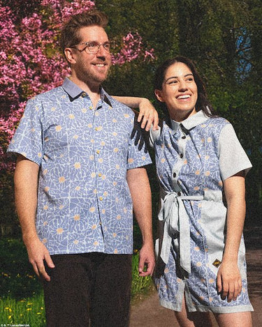 Couples standing in a park wearing a star wars themed rebel button up shirt and matching button up dress