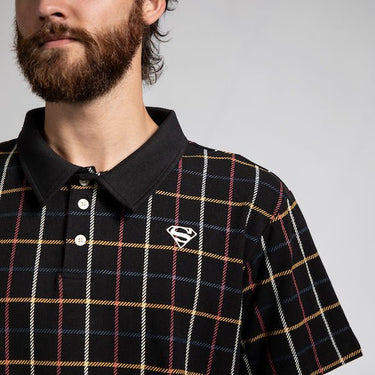 A close up of a man in a black plaid polo style shirt with red, white, blue and yellow stripe pattern. The photo shows a focused on the 2 button details and the "S-Shield" Embroidered on the chest