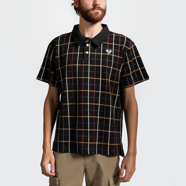 A man in a black plaid polo style shirt with red, white, blue and yellow stripe pattern. 
