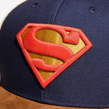 A close up of a blue hat showing an embroidered S-Shield 