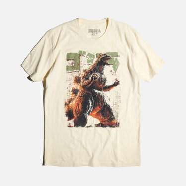 Natural-colored T-shirt featuring a vintage-style graphic of Godzilla roaring with a distressed design, Japanese text, and green block lettering.