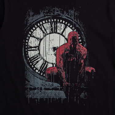 Moody, black, graphic tee featuring Daredevil crouched in front of a weathered clock tower, drenched in rain. The distressed artwork and bold red highlights capture the grit and intensity of Hell’s Kitchen’s vigilante.








