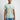 Person wearing a light green t-shirt with Marvel graphic design on a plain background