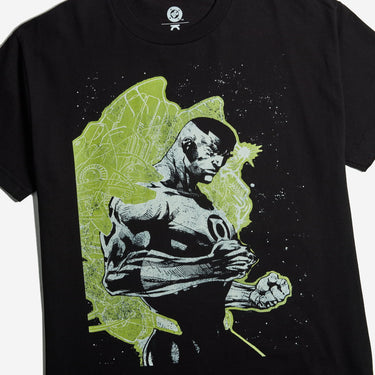 A  black short-sleeve graphic t-shirt with a stylized print of Green Lantern, set against a lime green and black background on a solid gray studio background.