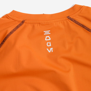 Close-up of an orange rebel garment with a brand logo on a white background