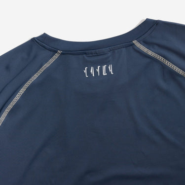 Navy blue long-sleeve shirt with white stitching on a light gray background