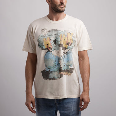 Person wearing a t-shirt with a graphic design of a character's fists and the word 'Hulk'.