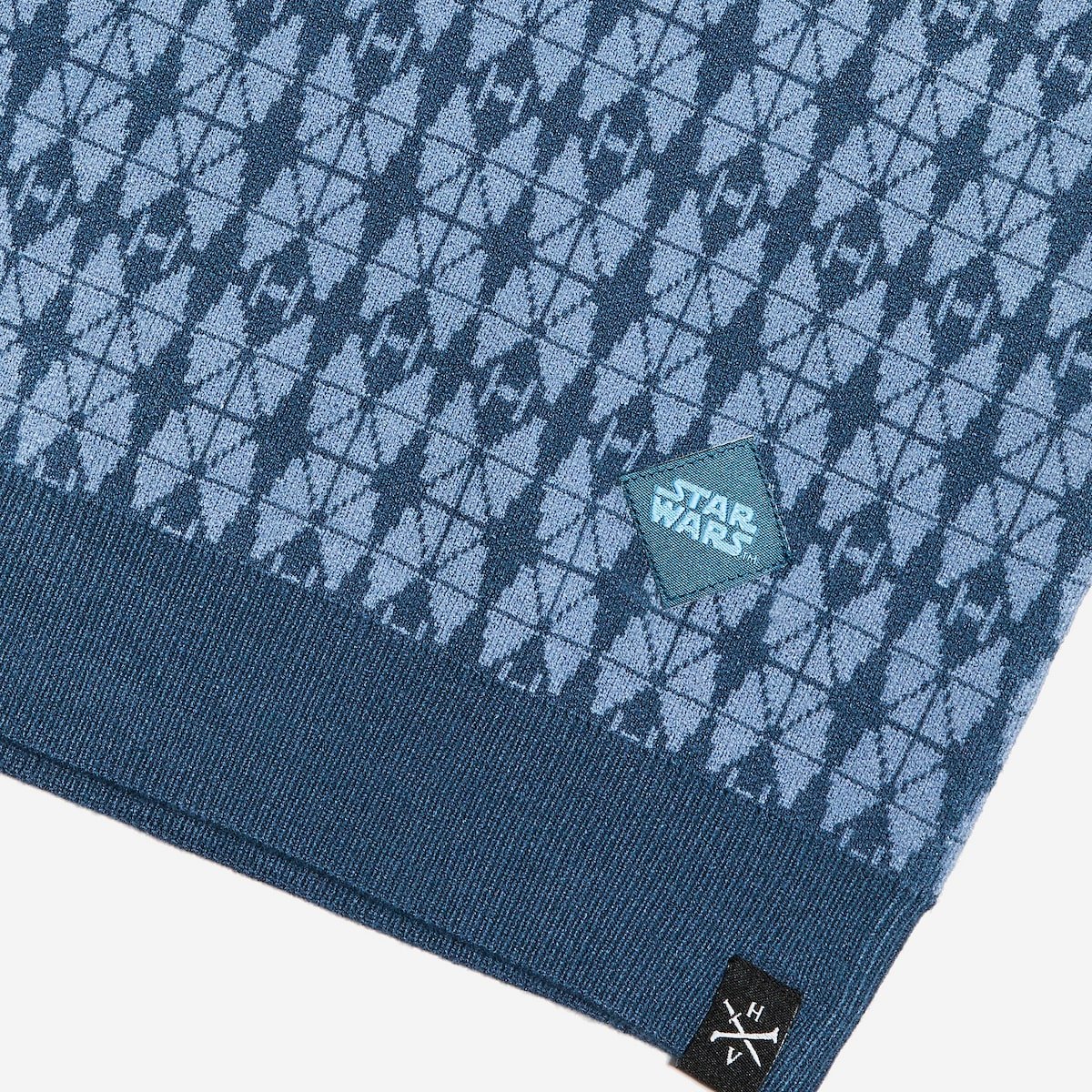 Close up of the polos hem fabric with 'Star Wars' logo and brand label on a white background