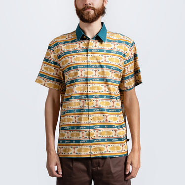 A man in a button up yellow and teal shirt with a star wars jedi motif in a striped pattern