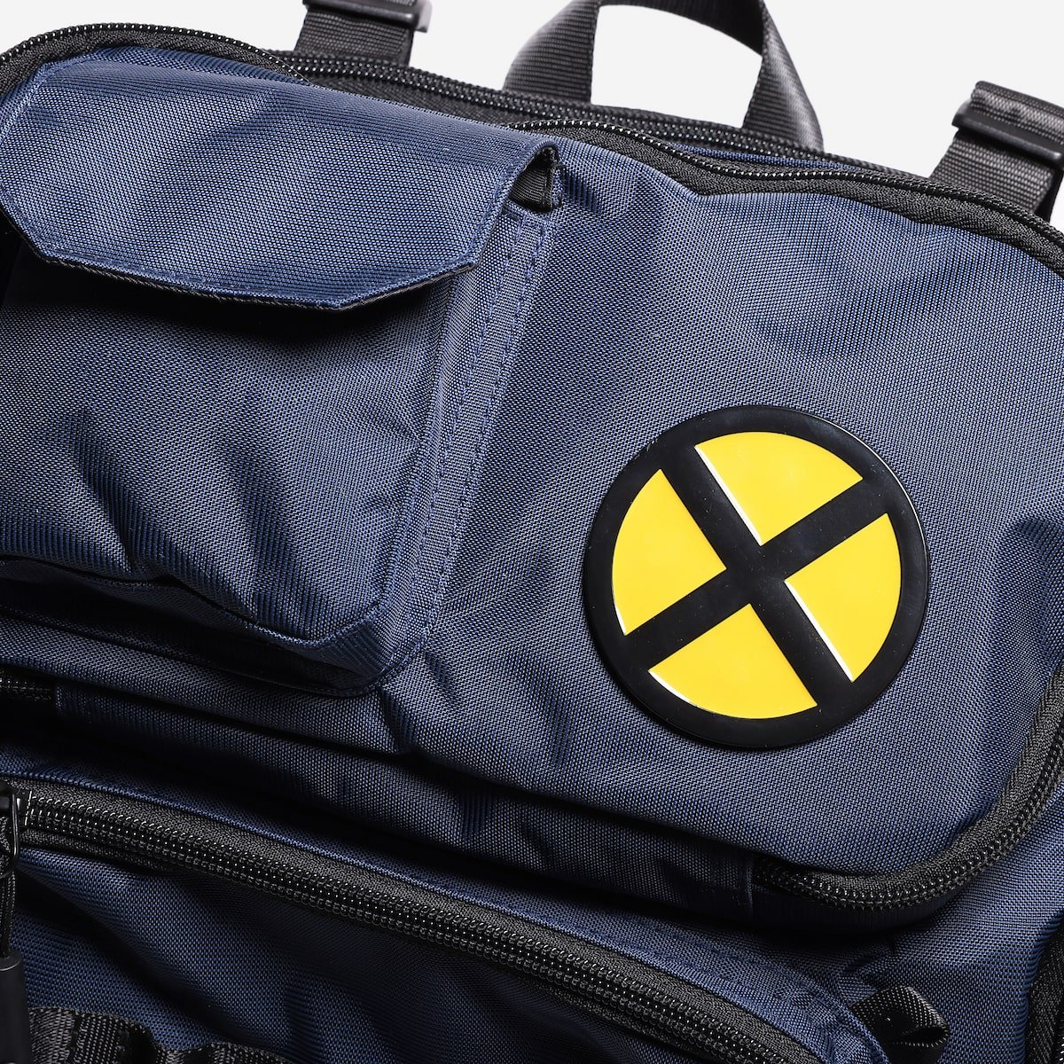 Blue bag with a yellow and black circular emblem featuring a large 'X'.