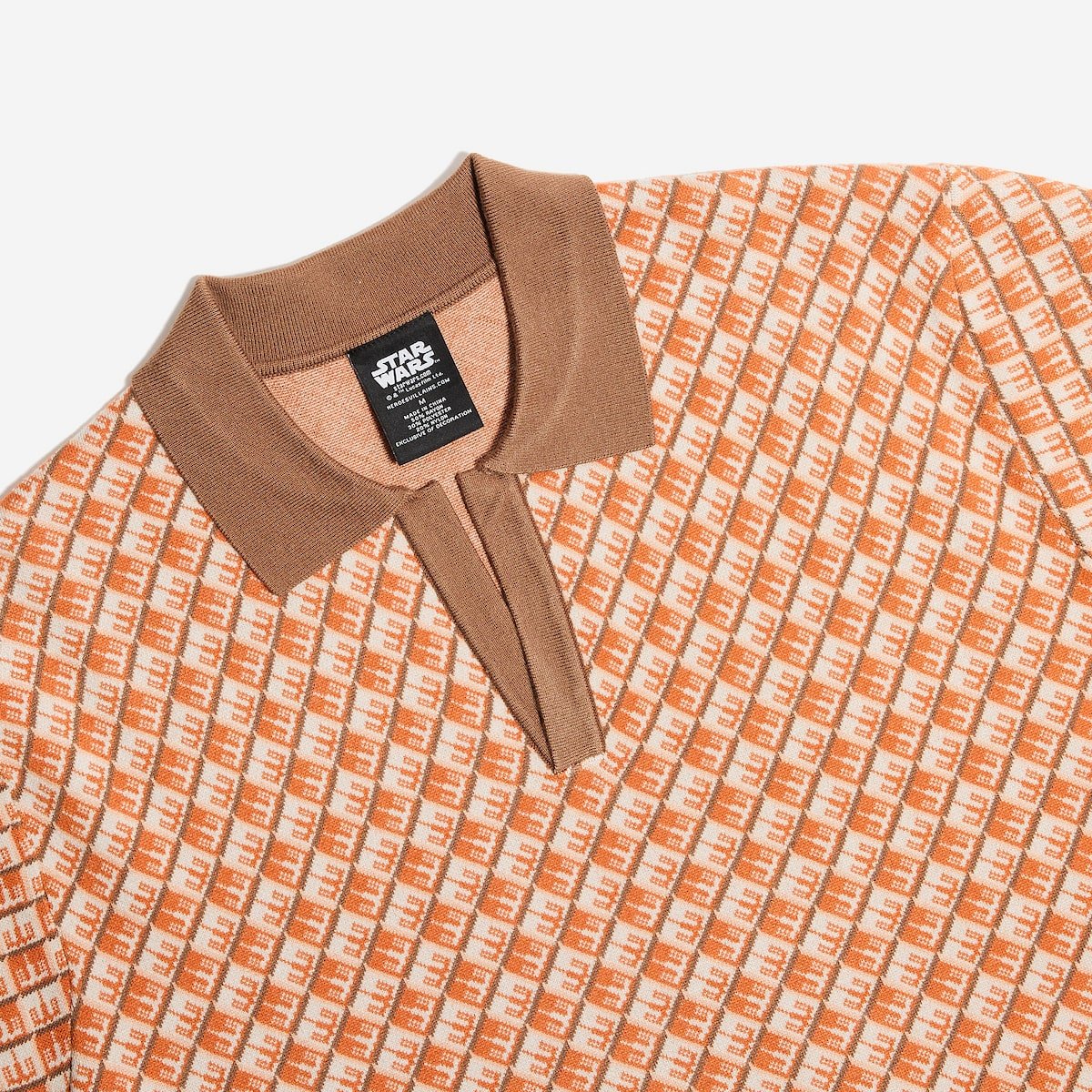 Close-up of a patterned shirt with a brown collar and visible brand tag on a white background