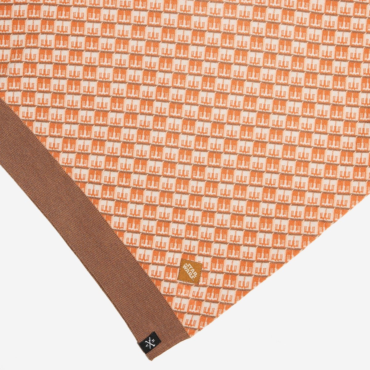 Close up of the polos hem fabric with 'Star Wars' logo and brand label on a white background