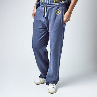 Man in Blue sweatpants with an elastic waistband and yellow drawstring, featuring a small yellow x-men logo near the left pocket and a vertical "Xavier" graphic printed in distressed yellow text along the lower left leg.