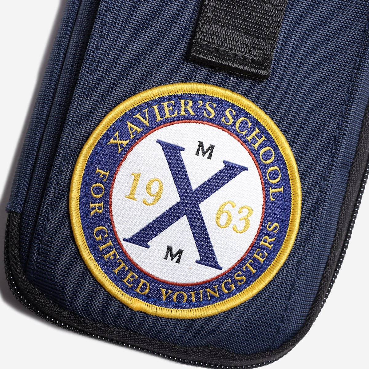 Navy blue bag with Xavier's School emblem featuring the year 1963.